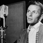Frank Sinatra en studio vers 1947, en costume, devant un micro