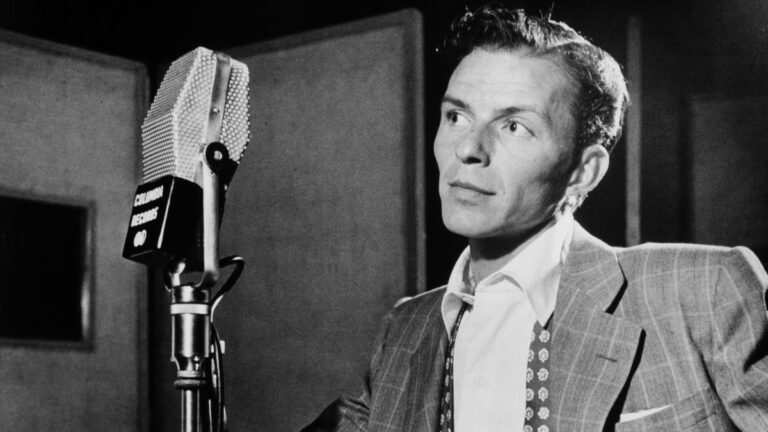 Frank Sinatra en studio vers 1947, en costume, devant un micro